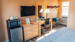 a room with a desk with a television and a computer at Quiet Corner Inn in Brooklyn