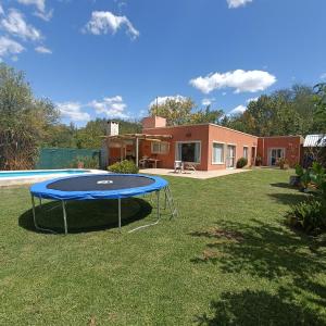 un trampolín en un patio frente a una casa en Los Cardales Mia en Los Cardales