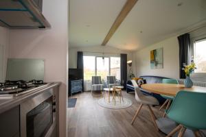 a kitchen and living room with a table and chairs at Chalets op Minicamping Dorpszicht in Gapinge