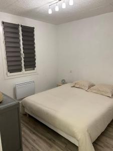 Un dormitorio blanco con una cama grande y una ventana en Jolie Villa indépendante climatisée 3 chambres tout confort 6 couchages, piscine chauffée 4 X 8 disponible de Juin à fin Septembre, grand terrain clos, boulodrome éclairé, ping-pong, wifi, proche commerces et commodités Animaux domestiques sur demande en Bretenoux