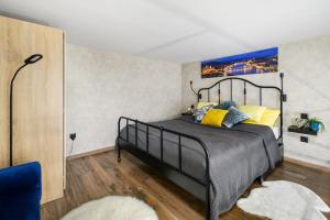 a bedroom with a black bed with yellow pillows at Luxury apartment in the city center with parking in Budapest