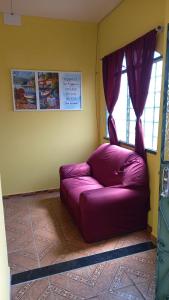 un sofá púrpura en una habitación con ventana en Ótimo apartamento, en Manaus