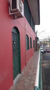un edificio rojo con una puerta verde en una calle en Ótimo apartamento, en Manaus