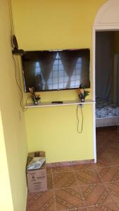 pared amarilla con estante en una habitación en Ótimo apartamento, en Manaus