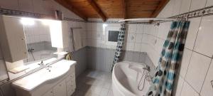 y baño con bañera, lavamanos y ducha. en Kallistimon House en Ypsos