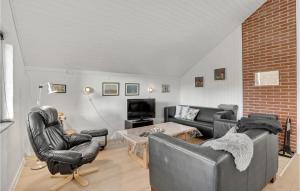 a living room with leather furniture and a brick wall at Pet Friendly Home In Oksbøl With Wifi in Oksbøl