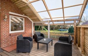 a covered deck with chairs and a table at Pet Friendly Home In Oksbøl With Wifi in Oksbøl +14 photos
