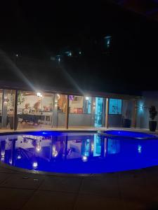 a large swimming pool at night with blue lights at Pousada Recanto da Cascata in Águas de Lindóia