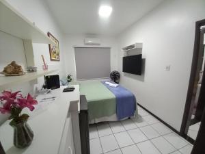 a small room with a bed and a screen at Village - Condomínio Mansão da Lagoa in Salvador