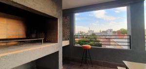 Habitación con chimenea y ventana con vistas. en Complejo de departamento lencinas en Godoy Cruz