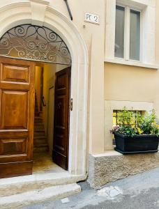 an entrance to a building with a door and plants at B&B CORSO VITTORIO EMANUELE - Nel pieno centro storico in LʼAquila