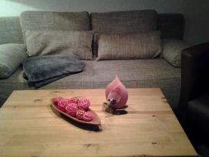 una bandeja de rosas en una mesa frente a un sofá en Ferienwohnungen Harling, en Erbach