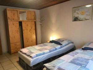 Habitación con 2 camas y puerta con armario en Ferienwohnungen Harling, en Erbach