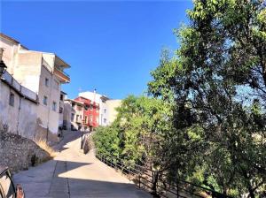 una calle vacía con edificios y un árbol a un lado en Casa Rural Taíno, en Benilloba