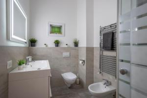 a white bathroom with a toilet and a sink at Green House San Siro in Milan