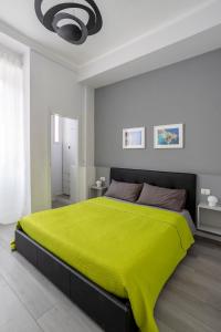 a large bed with a green blanket on top of it at Green House San Siro in Milan