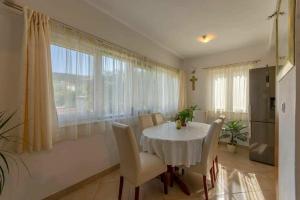 a dining room with a white table and chairs at Apartment Nikolina in Vinišće