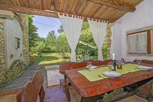 ein Esszimmer mit einem Tisch und einem Fenster in der Unterkunft Filip in Kraj Drage (Haus für 4-5 Personen) in Nedeščina