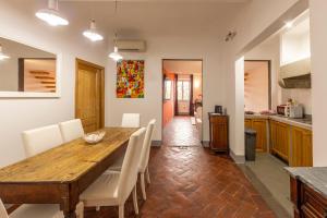 佛羅倫斯的住宿－Santo Spirito Apartment，厨房以及带木桌和椅子的用餐室。