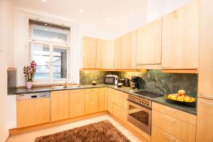 a large kitchen with wooden cabinets and a window at Wenceslas Square Lofts in Prague