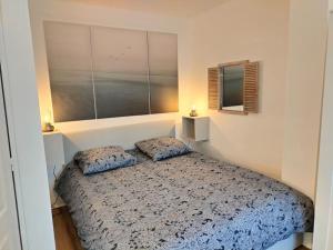 1 dormitorio con 1 cama con 2 almohadas en Locanoor Dieppe - Maison de Pêcheur devenue Cosy, en Dieppe