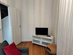 una sala de estar con TV en un armario blanco en Locanoor Dieppe - Maison de Pêcheur devenue Cosy, en Dieppe
