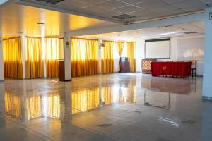 a large room with yellow curtains and a red table at Hotel Per&uacute; Pac&iacute;fico in Lima