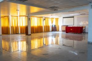 una grande stanza con tende gialle e un tavolo rosso di Hotel Perú Pacífico a Lima