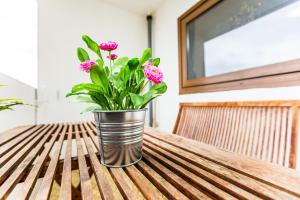 eine Vase mit rosa Blumen auf einem Tisch in der Unterkunft Apartment Köln Neubrück in Köln