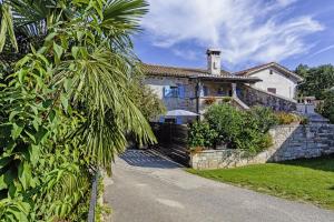 a house with a palm tree in front of it at Erisa in Trošti (Haus für 6 Personen) in Pazin