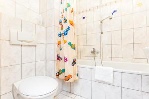 a bathroom with a toilet and a shower curtain at Apartment Köln Neubrück in Cologne