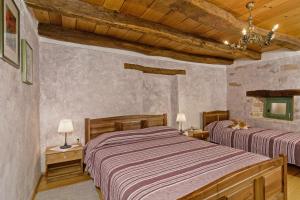 two beds in a bedroom with wooden ceilings at Erisa in Trošti (Haus für 6 Personen) in Pazin