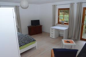 Schlafzimmer mit einem Bett, einem Schreibtisch und einem Fenster in der Unterkunft Apartment Albert in Erbach