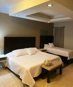 - une chambre avec 2 lits et une table dans l'établissement Hotel Magnolia, à Tampico