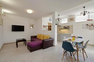 ein Wohnzimmer mit einem lila Sofa und einem Tisch in der Unterkunft Šmuketa in Trogir Haus für 4 Personen in Trogir