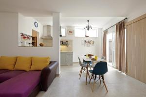 ein Wohnzimmer mit einem lila Sofa und einem Tisch in der Unterkunft Šmuketa in Trogir Haus für 4 Personen in Trogir