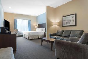 a hotel room with a couch and a bed at Best Western Plus Liverpool Hotel & Conference Centre in Liverpool