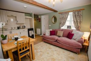 ein Wohnzimmer mit einem roten Sofa und einer Küche in der Unterkunft Pigsty Cottage - Rudge Farm Cottages in Bridport + 34 Fotos