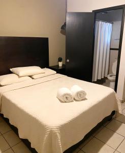 a bedroom with a large bed with towels on it at Hotel Magnolia in Tampico