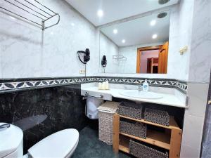 a bathroom with a sink and a toilet and a mirror at Casa El Secreto in Playa Jandia