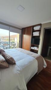 1 cama blanca grande en una habitación con ventana en Departamento Caseros Desings en Salta