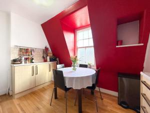 eine Küche mit einem Tisch und einer roten Wand in der Unterkunft Liberty Street in London