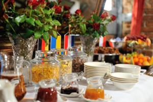 a table with jars of food and plates and flowers at Hotel Centrum Sosnowiec in Sosnowiec +81 photos