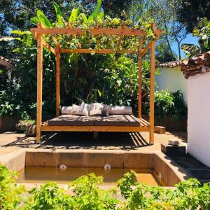 pérgola de madera con cama en un jardín en CASA CAFUNE - BARICHARA, en Los Cedros
