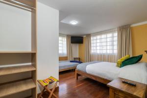 ein Hotelzimmer mit einem Bett, einem Schreibtisch und einem 6-dx-dx-Bett in der Unterkunft Corazon del Molino Corferias Bogota- Embajada Americana in Bogotá