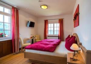 ein Schlafzimmer mit einem großen Bett mit einer lila Decke in der Unterkunft Landhaus Christophorus in Forbach