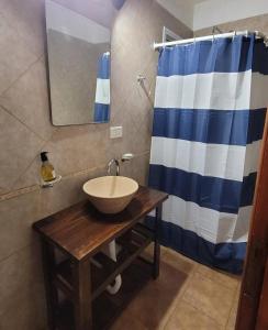 y baño con lavabo y ducha azul y blanca. en Dunas del Sur II en Villa Gesell