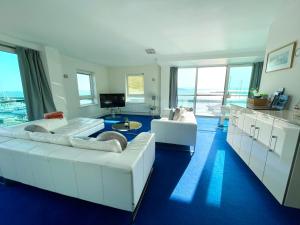 sala de estar con 2 sofás blancos y cocina en Quay & Sea View Spacious Modern Secure Parking, en Poole