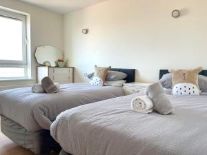 two beds sitting next to each other in a bedroom at Quay & Sea View Spacious Modern Secure Parking in Poole