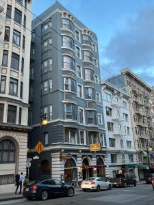 Un alto edificio grigio in una strada di città con le auto di The Andrews Hotel a San Francisco